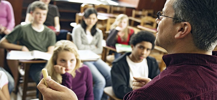 Over the shoulder view of students listening to teacher